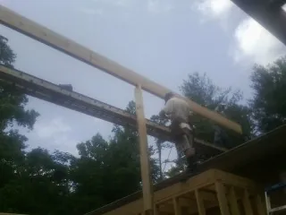 Carpenter setting a ridge beam over a new addition frame — Ice Dam Removal by Roofing Brothers in Brewer