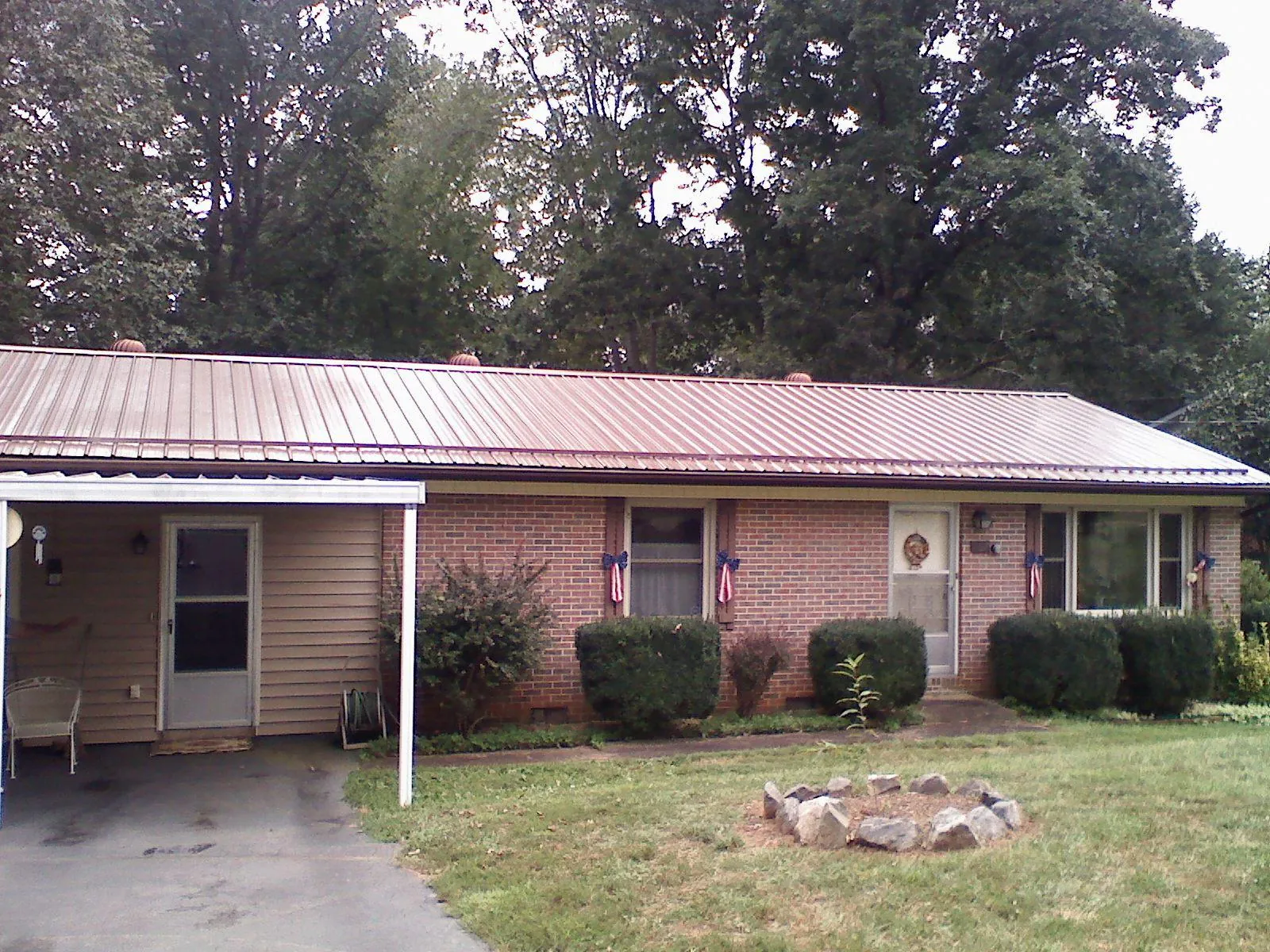 Bronze metal roof and carport on a brick ranch home — Roof Repair work by our crew in Brewer